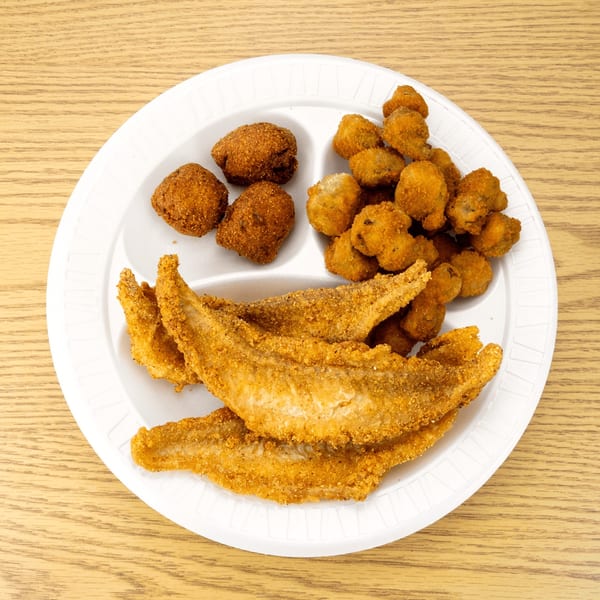 Fried fish fillets, hush puppies, and fried okra on a white divided plate.